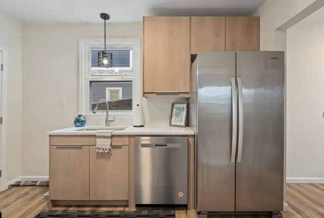 Kitchen with wood-grain slab cabinets, stainless appliances and wood-look flooring, St. Paul, MN