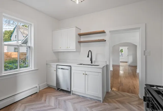 White shaker kitchen with floating shelves and herringbone flooring, St. Paul, MN