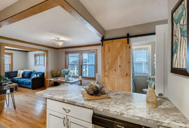 Kitchen peninsula open to the dining and living rooms, with a sliding barn door, St. Paul, MN