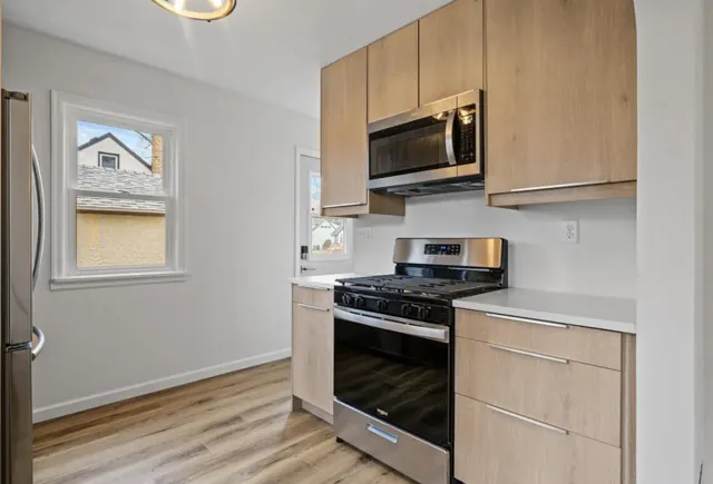 Kitchen with slab cabinets, gas range and new flooring, Twin Cities