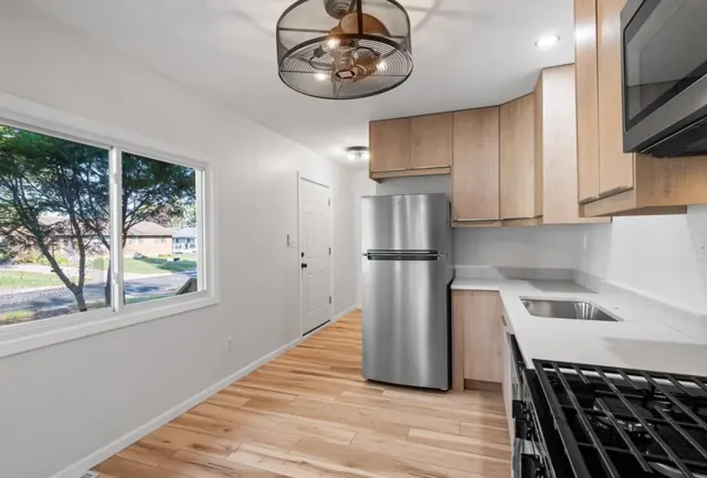 Kitchen with slab cabinets, white countertops and gas range, Twin Cities